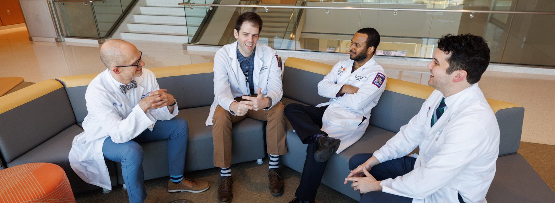 residents and faculty sitting on couch conversing